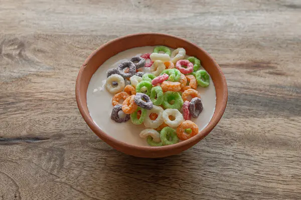 Multicolored grain or corn rings. Breakfast with yogurt. Clay bowl. Balanced nutrition. Healthy Lifestyle. Colorful food. Nutritious snack.