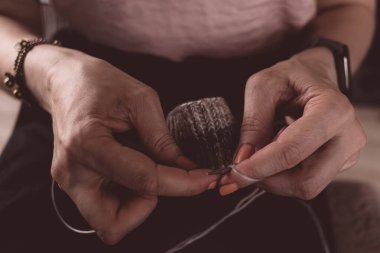 Sıcak bir fotoğrafta el yapımı kalın elbiseler ördüm. Kalın elbiseler ördüm. Kadınların hobisi. Örgü desenli. Örgü moda. El yapımı şeyler. Ev rahatlığı. Ellerinde örgü olan kız. Sonbahar ve kışın dinlenme zamanı.