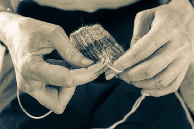 Sıcak bir fotoğrafta el yapımı kalın elbiseler ördüm. Kalın elbiseler ördüm. Kadınların hobisi. Örgü desenli. Örgü moda. El yapımı şeyler. Ev rahatlığı. Ellerinde örgü olan kız. Sonbahar ve kışın dinlenme zamanı.