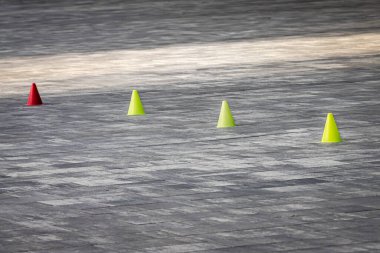 Asfalttaki renkli spor konileri eğitimde engel teşkil ediyor. Yoldaki parlak tabelalar. Patenciler ve patenciler için antrenman sahası. Çocuk eğlencesi. Ekstrem sporlar. Engelleri aşın.
