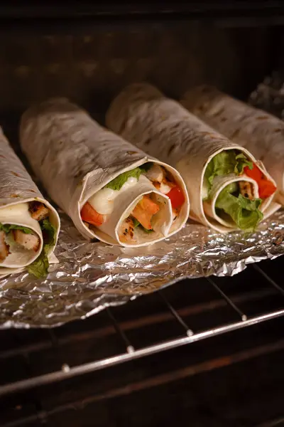 Sebzeli ve etli Shawarma ya da fırında ızgara ve folyoyla balık. Sokak yemeği. Sıcak yemek. Fırında pişir. Fırında rulo. Parti için menü. Ergenler için yemek. Bir şeyler atıştır. Afiyet olsun. Renkli ürünler. Ev yemeği. Besleyici yemek..