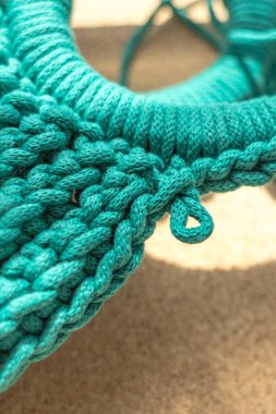 Yeşil pamuk ipten örülmüş şık bir çanta. Makrame tekniği. Bireysel düzen. El işi ürünü. Şık örgü. Kadın aksesuarı. Tığ işi çanta. Pamuk ipi. Tahta toka..