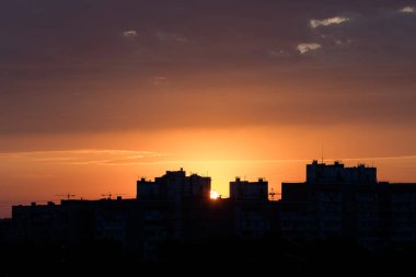 Turuncu gökyüzü. Kasabada sabah. Metropolün panoraması. Evlerin silueti. Huzurlu bir hayat. Sakin gökyüzü. Doğada renk değişimi var. Cennetlik manzara. Şehir silüeti.