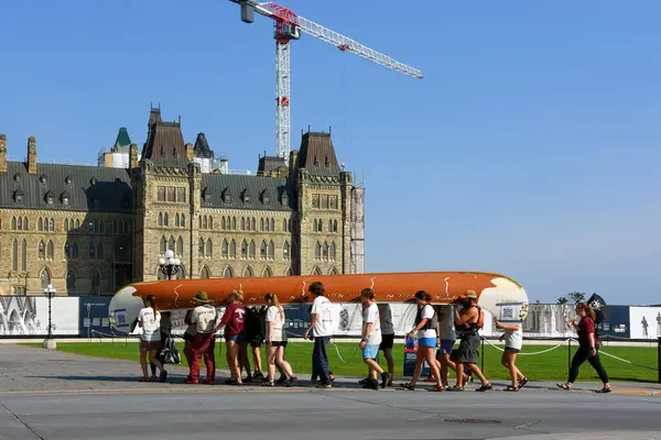 stock image Ottawa  2024 A group of young adults carry, or Portage a large canoe to Parliament Hill in an effort to raise money for charity In the 19th century many Canadians travelled by water and had to carry their canoes over land to get to the next waterway.