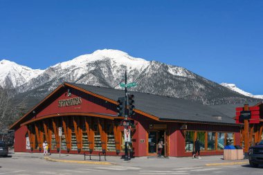 Canmore, Kanada - 4 Nisan 2025: Canmore, Alberta, Kanada 'da Stonewater mağazası ve Rocky Dağları arka planda. Canmore Calgary 'den 81 km uzakta popüler bir tatil köyü..