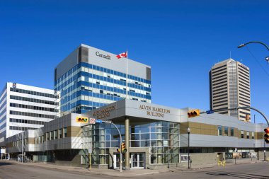 Regina, Kanada - 6 Nisan 2025: Hamilton Caddesi 'ndeki Alvin Hamilton Binası federal hükümet ve departmanların bulunduğu bir devlet binasıdır. Resimde bir Royal Bank ofis binası ve bir Delta Hotel de görülebilir.. 