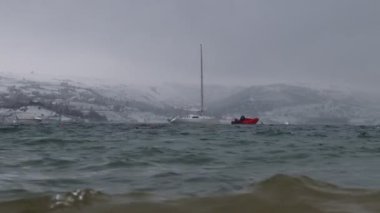 Stormy sea, snow and yachts