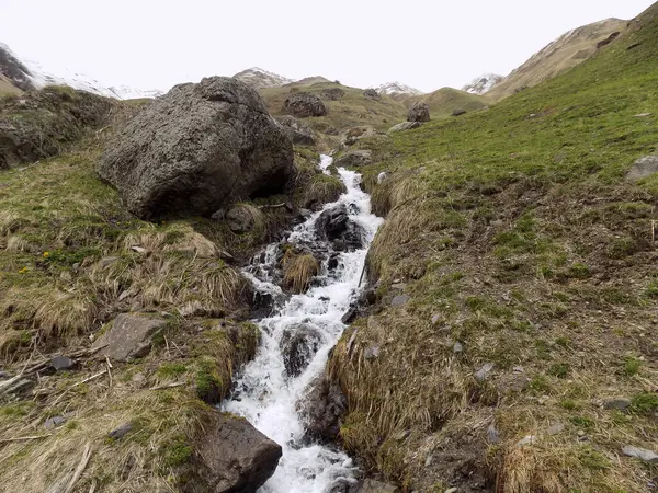 Nehir, büyük taşlar ve karlı dağlar. Juta, Gürcistan