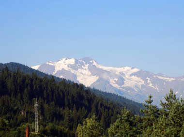 Güzel karlı dağ, orman ve mavi gökyüzü. Laila Dağı (Lahili), Svaneti, Georgia    