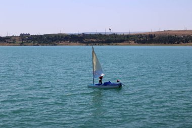 Mavi gölde küçük bir yelkenli.