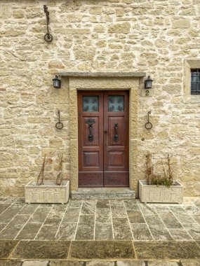Tuscany 'de bir İtalyan kasabasında tarihi, madalyalı bir apartman dairesi girişi.