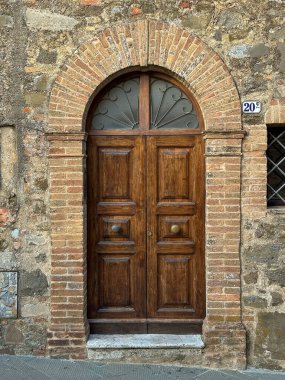 Tuscany 'de bir İtalyan kasabasında tarihi, madalyalı bir apartman dairesi girişi.