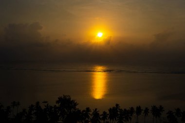 Sabah Kenya 'da güzel bir başlangıç. Sabah güneşi Hint Okyanusu' nun sakin sularına yansıyor. Sahildeki gölgeli palmiye ağaçlarını aydınlatıyor.
