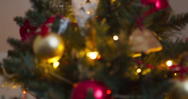 飾りやおもちゃでいっぱいのクリスマスツリー 装飾されたクリスマスツリーからぶら下がっ金の泡 アクセサリーやジンジャーブレッドの焦点を当てビュー メリークリスマスとハッピーホリデー 新年の雰囲気 — ストック動画