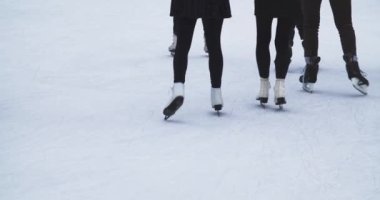 Mutlu bir grup insanın dışarıda buz pateni pistinde bir etkinliği var. Temiz beyaz buz yüzeyi. Spor ve eğlence konsepti, kış zamanı.. 