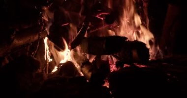 Şenlik ateşi, kamp ateşinde alevler. Yanan kırmızı kıvılcımlar gecenin küçük ateşinden yükselir..