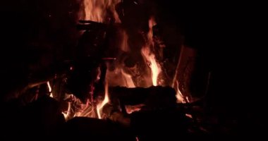 Şenlik ateşi, kamp ateşinde alevler. Yanan kırmızı kıvılcımlar gecenin küçük ateşinden yükselir..