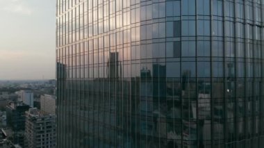 Alacakaranlık gökyüzünün ve şehrin yansıması yüksek katlı ayna camlı pencerelerde..