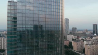 Alacakaranlık gökyüzünün ve şehrin yansıması yüksek katlı ayna camlı pencerelerde..