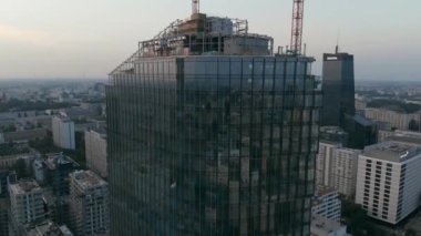 Alacakaranlık gökyüzünün ve şehrin yansıması gökdelenlerin aynalı pencereleri inşa ediyor..