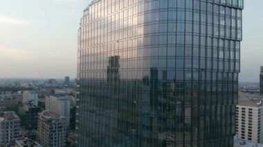 Alacakaranlık gökyüzünün ve şehrin yansıması yüksek katlı ayna camlı pencerelerde..