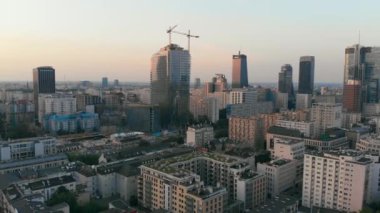 Varşova şehrinin tepesinden hava aracı görüntüsü alacakaranlıkta yükseliyor, Polonya 'da yüksek bir binanın inşaat alanı.