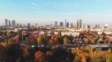 Günbatımında güzel turuncu ve sarı ağaçlarla birlikte Varşova şehir merkezinin hava manzarası. Trafik sıkışık.