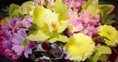 Renkli çiçeklerden oluşan yakın plan bir buket. Evlilik yıldönümü. Bir kadın için hediye. Bir buket çiçek. Çiçek buketlerinin teslimatı. Seçici odak, yüzeysel alan derinliği