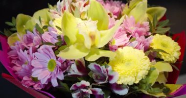 Renkli çiçeklerden oluşan yakın plan bir buket. Evlilik yıldönümü. Bir kadın için hediye. Bir buket çiçek. Çiçek buketlerinin teslimatı. Seçici odak, yüzeysel alan derinliği