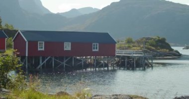 Norveç, Lofoten 'de Rorbu adında kırmızı balıkçı kulübeleri. Küçük örgülü sakin bir göl. Statik çekim