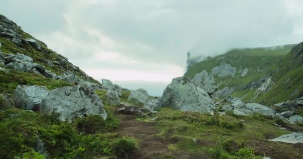 曇りの日に岩だらけの地形のシーンで劇的な気分 美しいノルウェー諸島 ロフテン島 クヴァルビカビーチ 手前の岩と奥の雲に覆われた山 — ストック動画