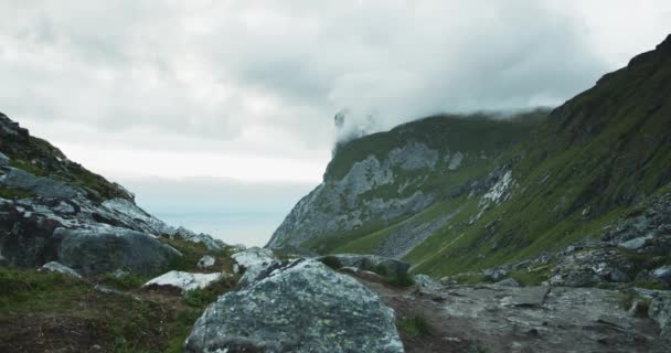 多云的天气里 岩石地形中的戏剧化气氛 美丽的挪威群岛 罗浮敦群岛 静态射击 前景上的岩石 背景上覆盖着云彩的山 — 图库视频影像
