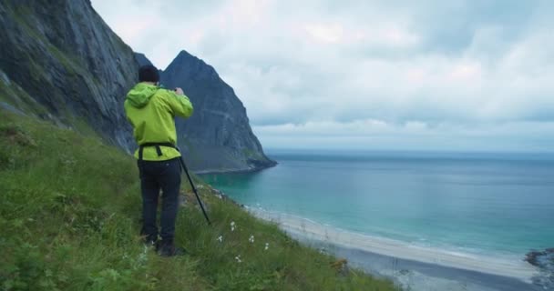 自然写真家は曇りの日にKvalvikaビーチロフトテン島の隣の北欧のフィヨルドの写真を撮っています — ストック動画