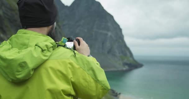 站在Kvalvika海滩旁边的自然摄影师 带着相机拍照 多云的天气下美丽的挪威罗浮敦群岛 — 图库视频影像