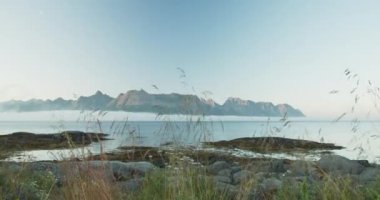 Yavaş hareket eden alçak bulutlarla dağ manzarası manzarası. Lofoten Adaları, kayalık kıyı, güneşli sabah ve Norveç fiyortlarında güzel doğa.