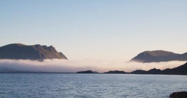 Yavaş hareket eden alçak bulutlarla dağ manzarası manzarası. Lofoten Adaları, güneşli bir sabah ve Norveç fiyortlarında güzel bir doğa. Gökyüzünde metin alanını kopyala veya kopyala.