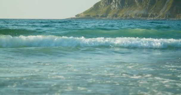 卷起的波浪正接近海岸 碧绿的大海 轻松自在地观赏着浪涌向沙滩的美景 背景是一座巨大的山 — 图库视频影像