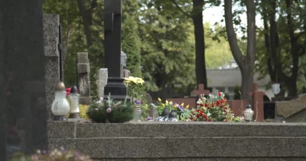 ろうそくと花で墓地の墓石の景色 ワルシャワの墓地にある灰色の大理石の墓石 死と死の概念 — ストック動画