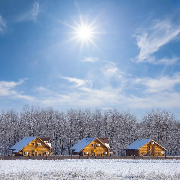 冬の晴れた日に森の境界で雪に覆われた小さな村季節の田園風景 — ストック写真