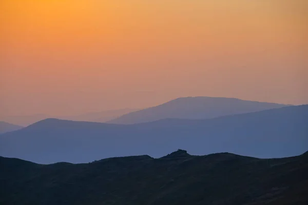 夕日の青い霧の中の山岳チェーンシルエット早朝の山岳旅行シーン — ストック写真