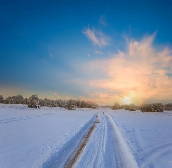Droga Gruntowa Wśród Śnieżnej Równiny Przy Dramatycznym Zachodzie Słońca Zima — Zdjęcie stockowe