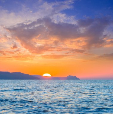 sea cliff silhouette among sea at the dramatic sunset, summer evening sea background