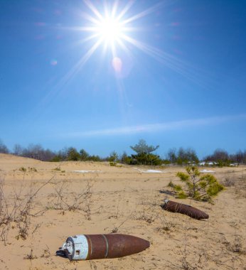 Yakın çekim askeri mühimmat güneşli bir günde çayırların arasında yatıyor.