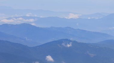 mountain chain silhouette in blue mist, natural mountain travel background