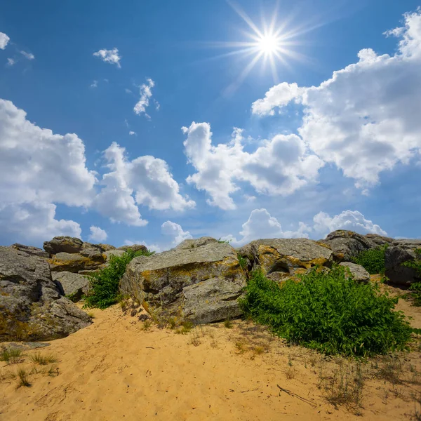 輝く太陽の下で砂の丘の上の巨大な石のヒープ — ストック写真