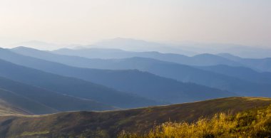 Yakın dağ vadisinde, güneşin doğuşunda yoğun bir sis var. Sabah erken saatlerde dağ manzarası.