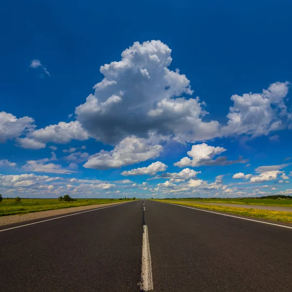 Długa Asfaltowa Droga Odjeżdżająca Daleko Pod Chmurnym Niebem — Zdjęcie stockowe