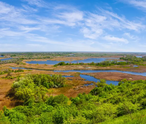 緑の丘から青い空の下草原の間の青い川への眺め — ストック写真