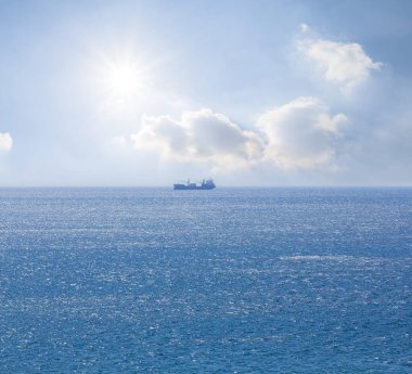 Işıl ışıl güneş altında mavi denizin ortasında tek başına kargo gemisi, deniz taşımacılığı arka planı