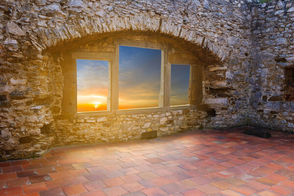 View to the sunset from window, old medieval castle indoor scene